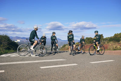 Group of bikers taking a break in a lush green valley surrounded by hills.