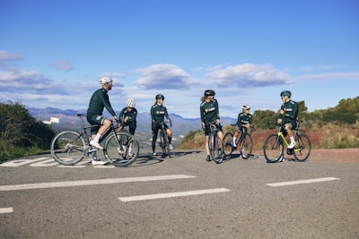 Cyclists smiling and chatting during a break on a scenic hilltop overlooking Montauban.