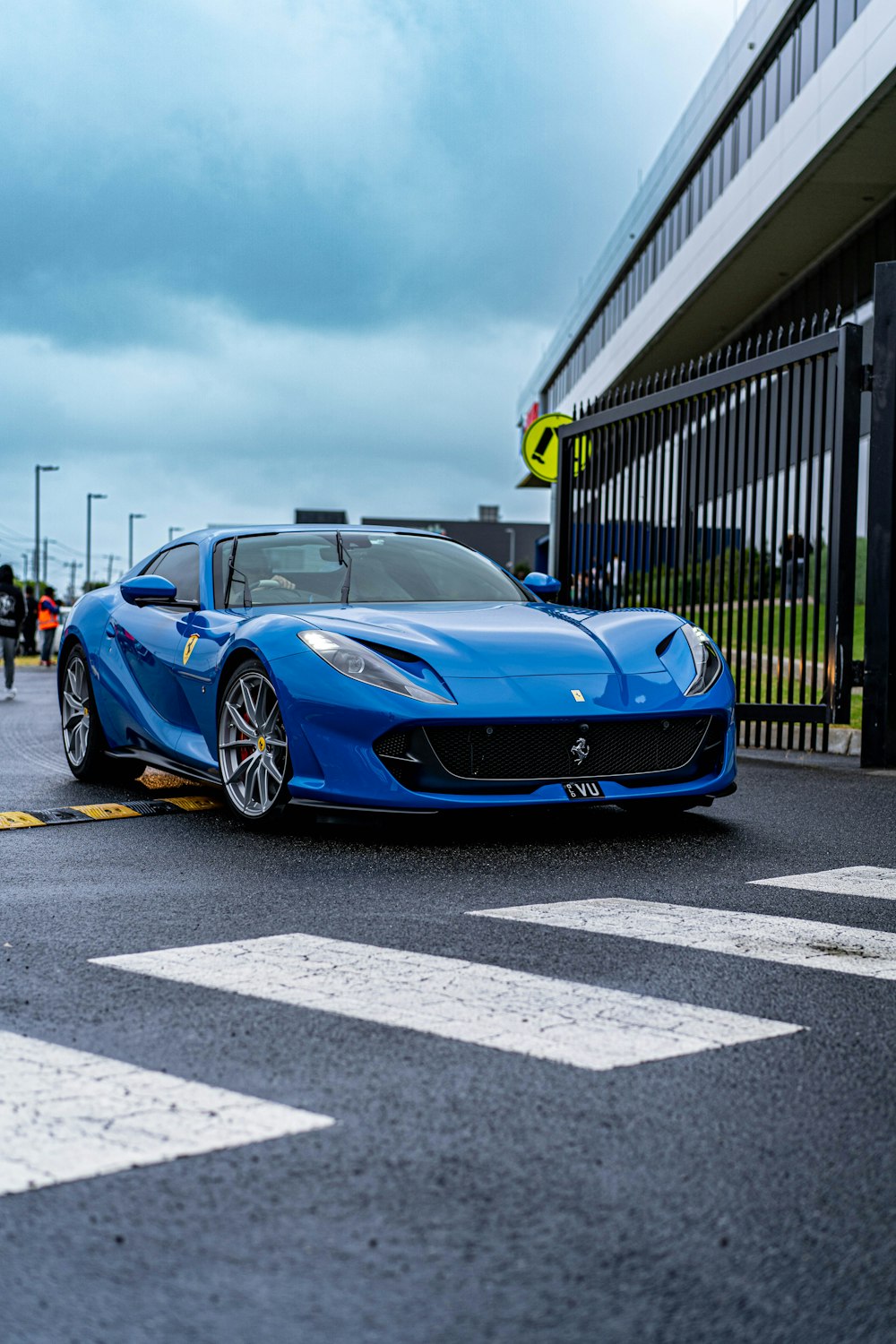 a blue sports car parked in front of a building