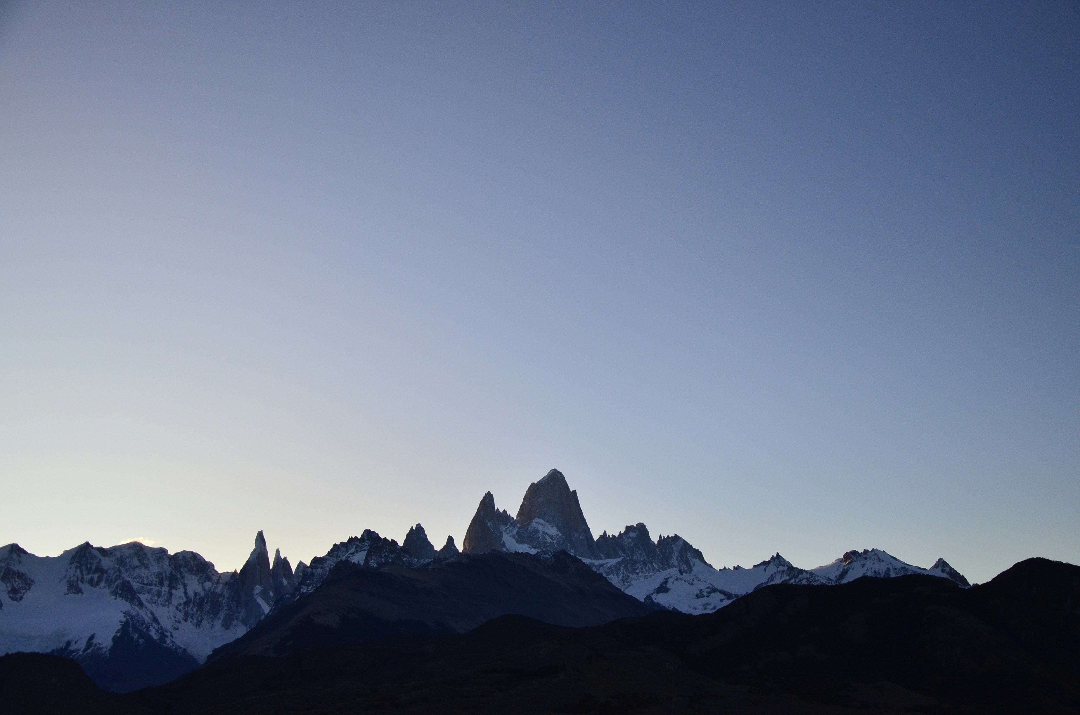 a mountain range with snow capped mountains in the background, 