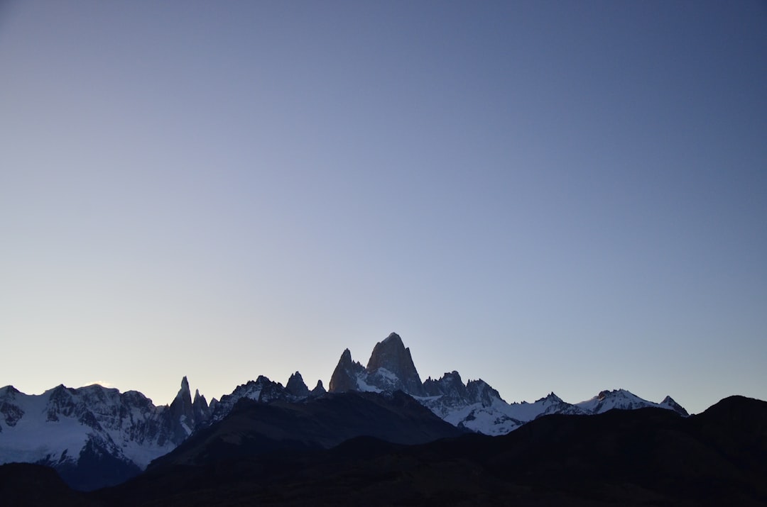 a mountain range with snow capped mountains in the background,