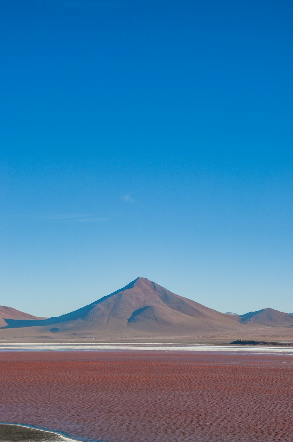 a large body of water with a mountain in the background