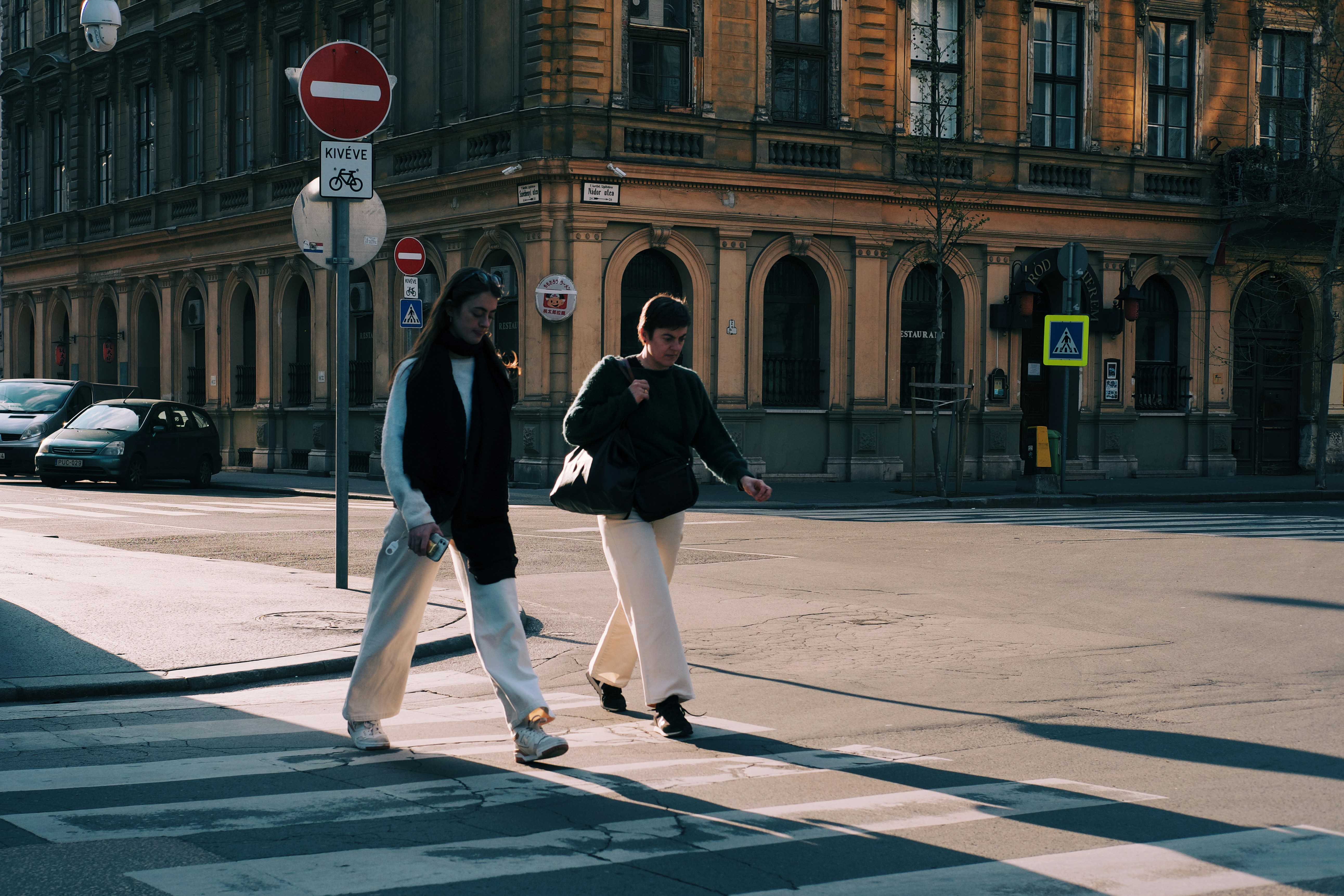 a couple of people that are walking across a street