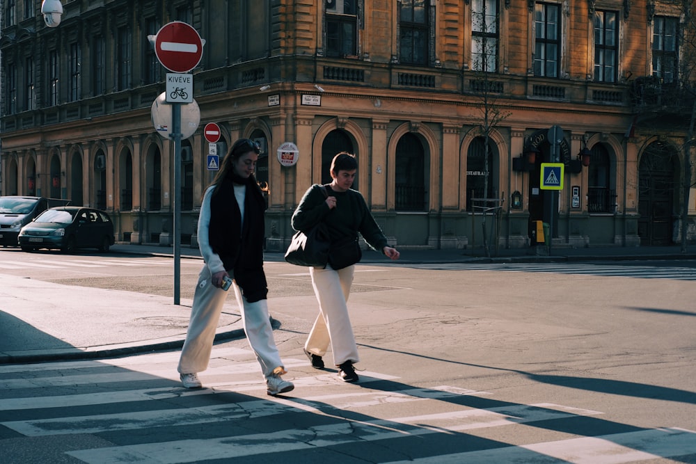 a couple of people that are walking across a street