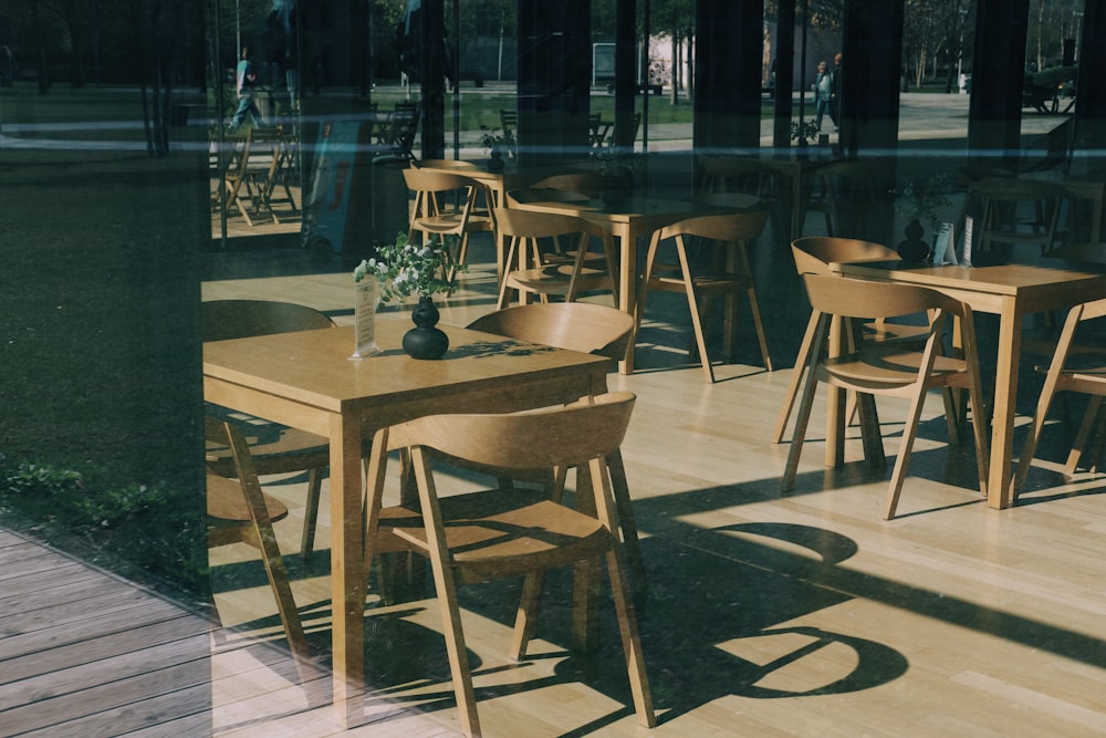 a wooden table with chairs and a vase of flowers