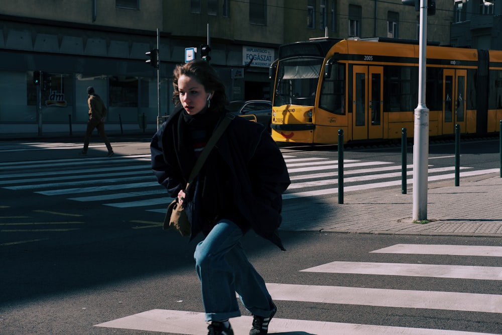 a woman riding a skateboard across a cross walk