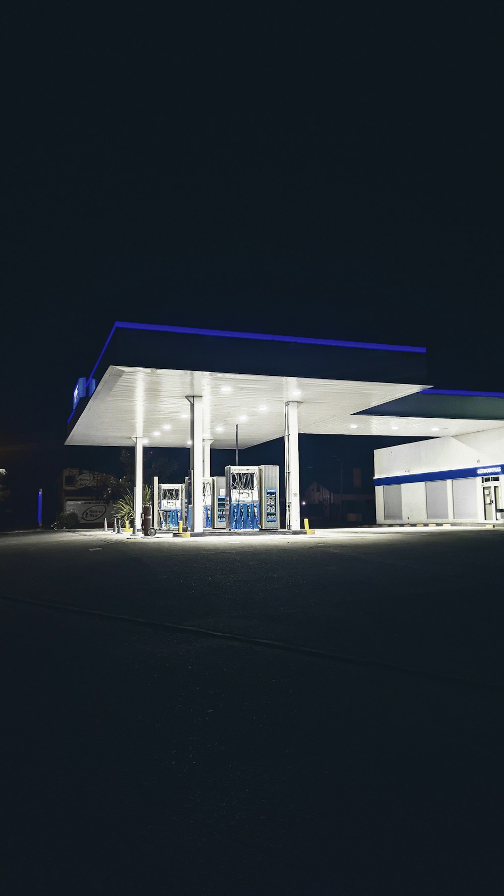 a gas station lit up at night time