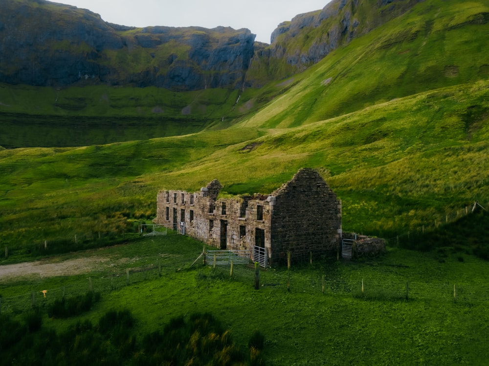 an old stone building in a green valley