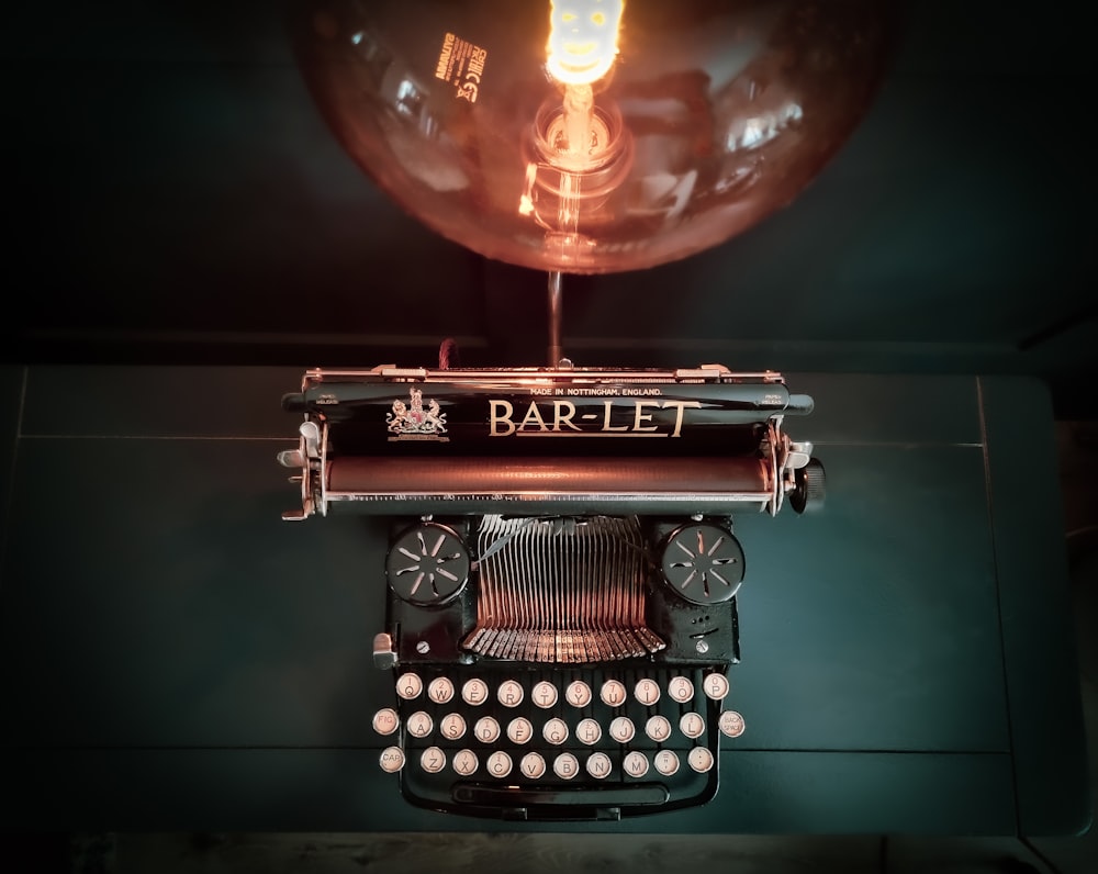 an old fashioned typewriter with a lamp above it