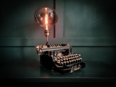 an old fashioned typewriter with a light bulb on top of it