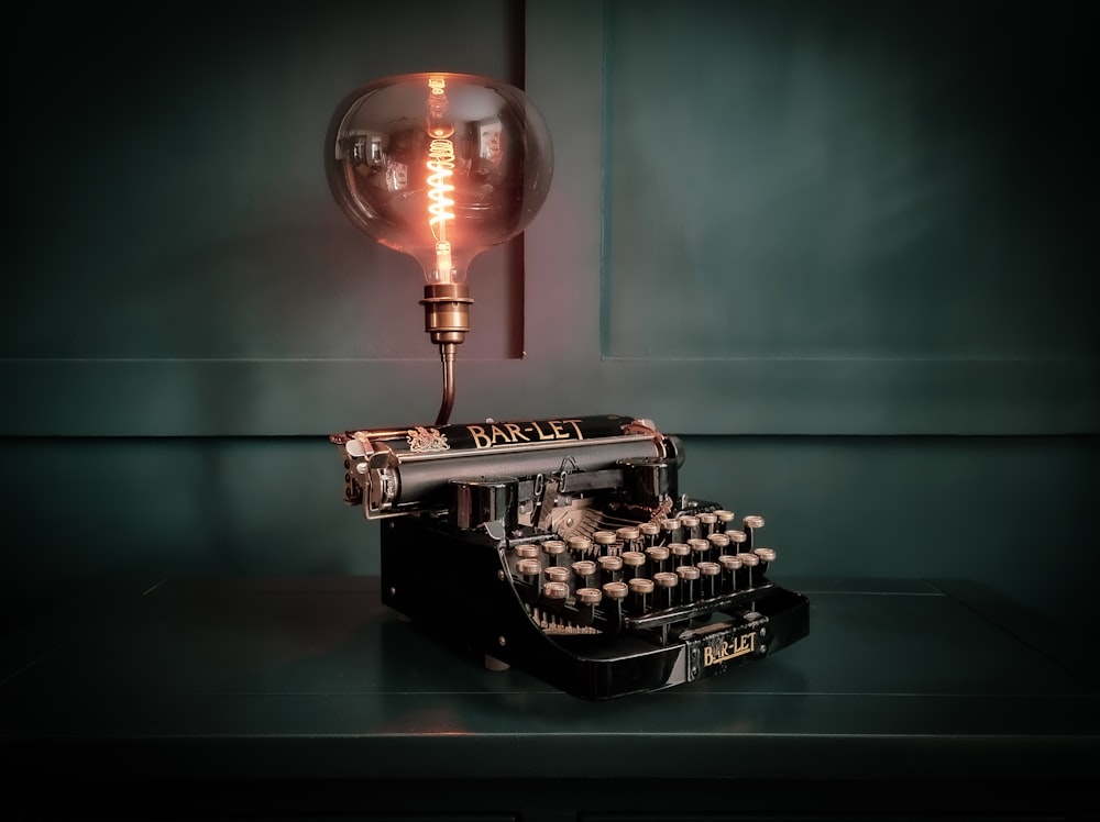 uma máquina de escrever antiquada com uma lâmpada em cima dela