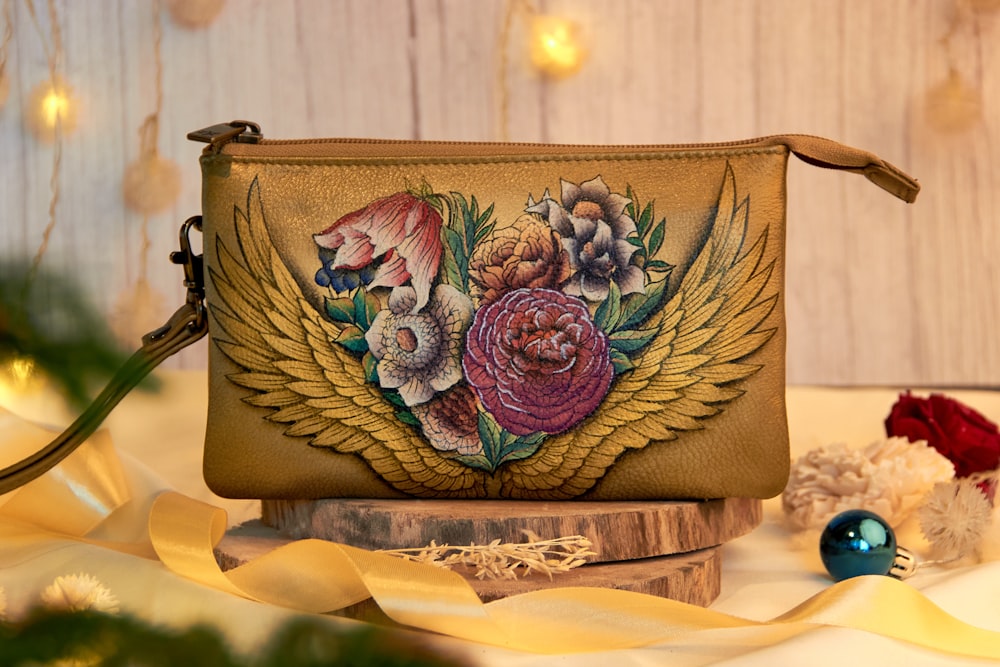 a small purse with flowers painted on it