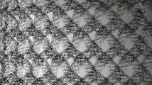 Intricate overlapping wire patterns forming abstract interconnected loops, creating a visually complex and dynamic design. The wires appear to weave in and out, suggesting depth and movement.