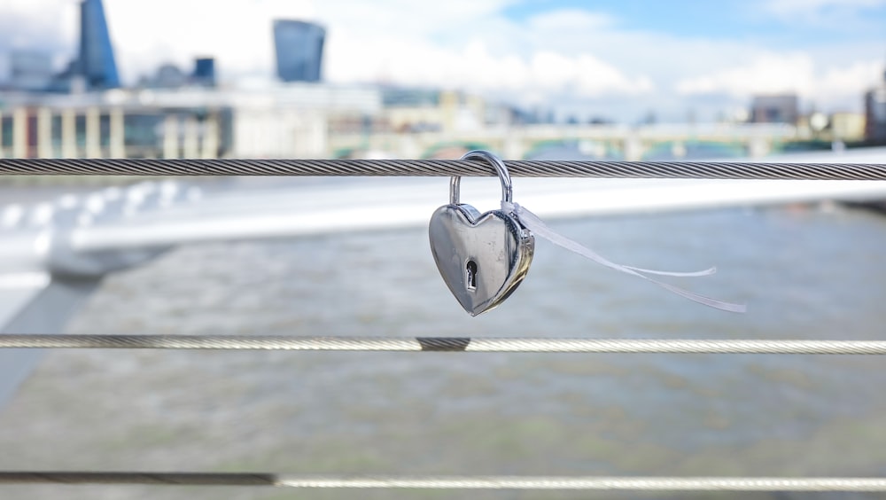 a heart shaped padlock hanging on a rope