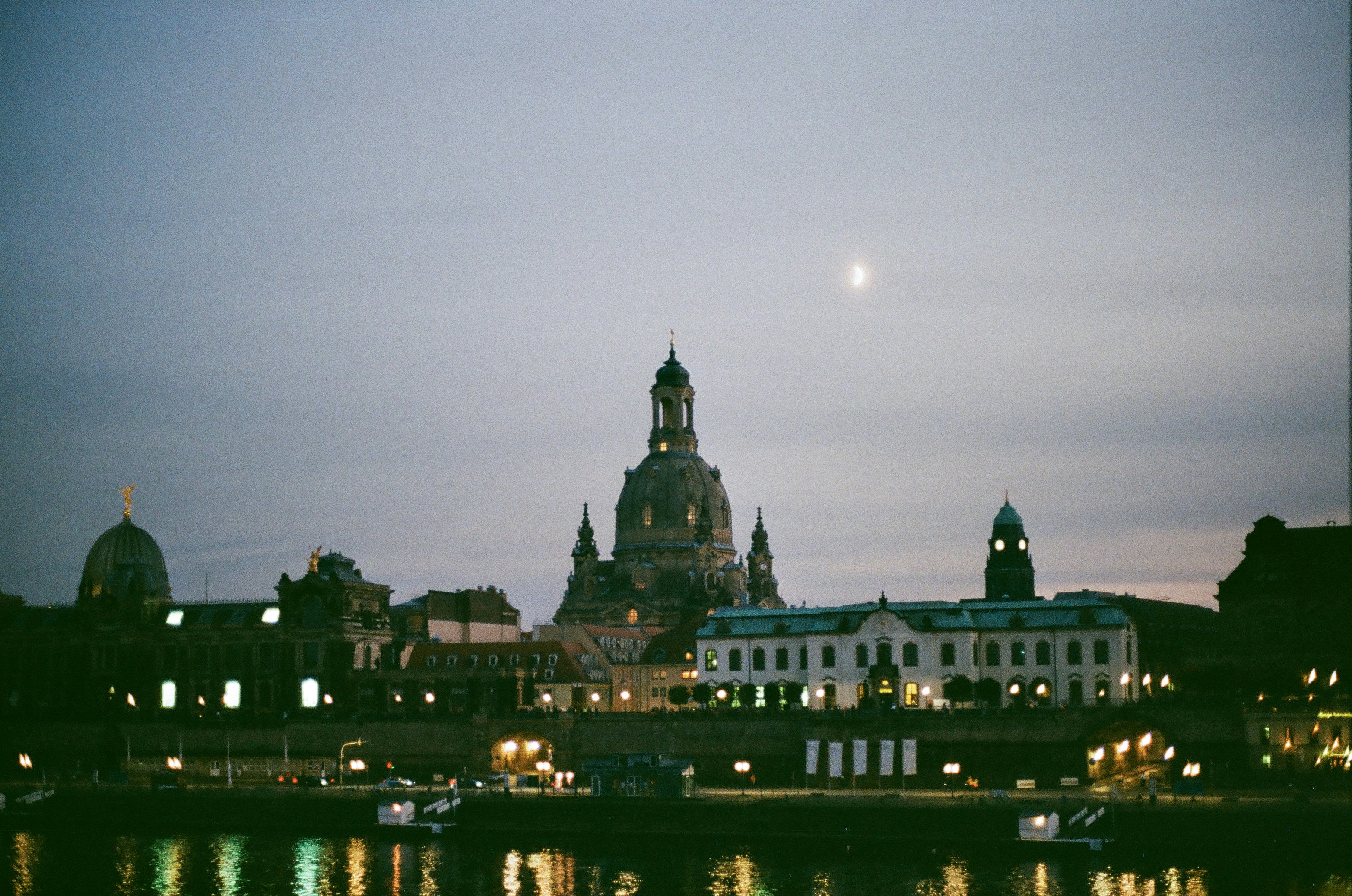a large building with a clock tower next to a body of water