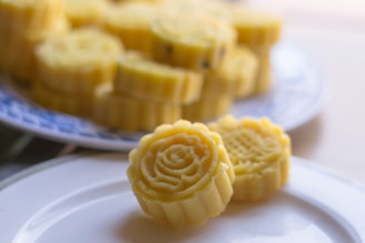 Close-up of exquisitely decorated artisanal pastries resembling delicate blooming flowers on a rustic wooden table.