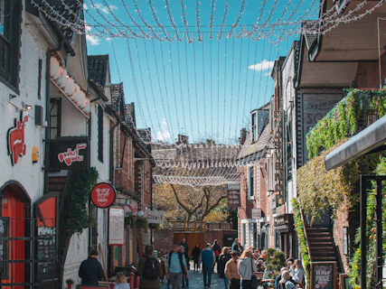 a group of people walking down a street next to buildings