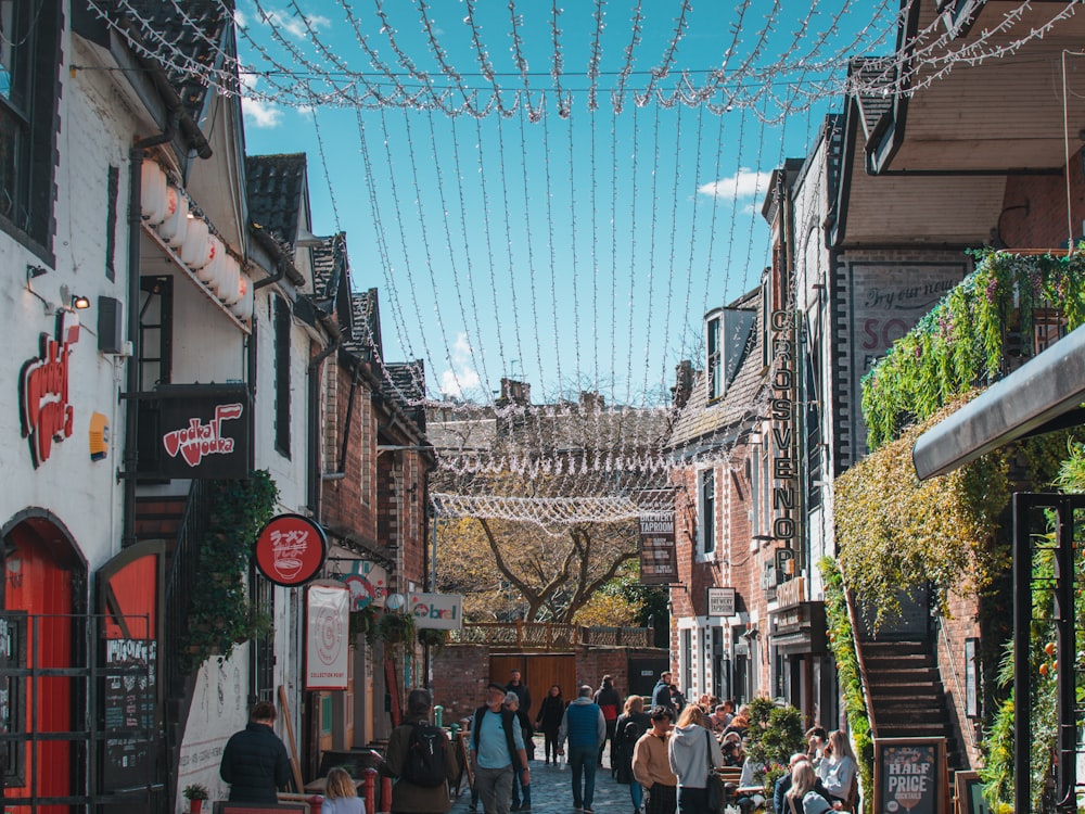 a group of people walking down a street next to buildings