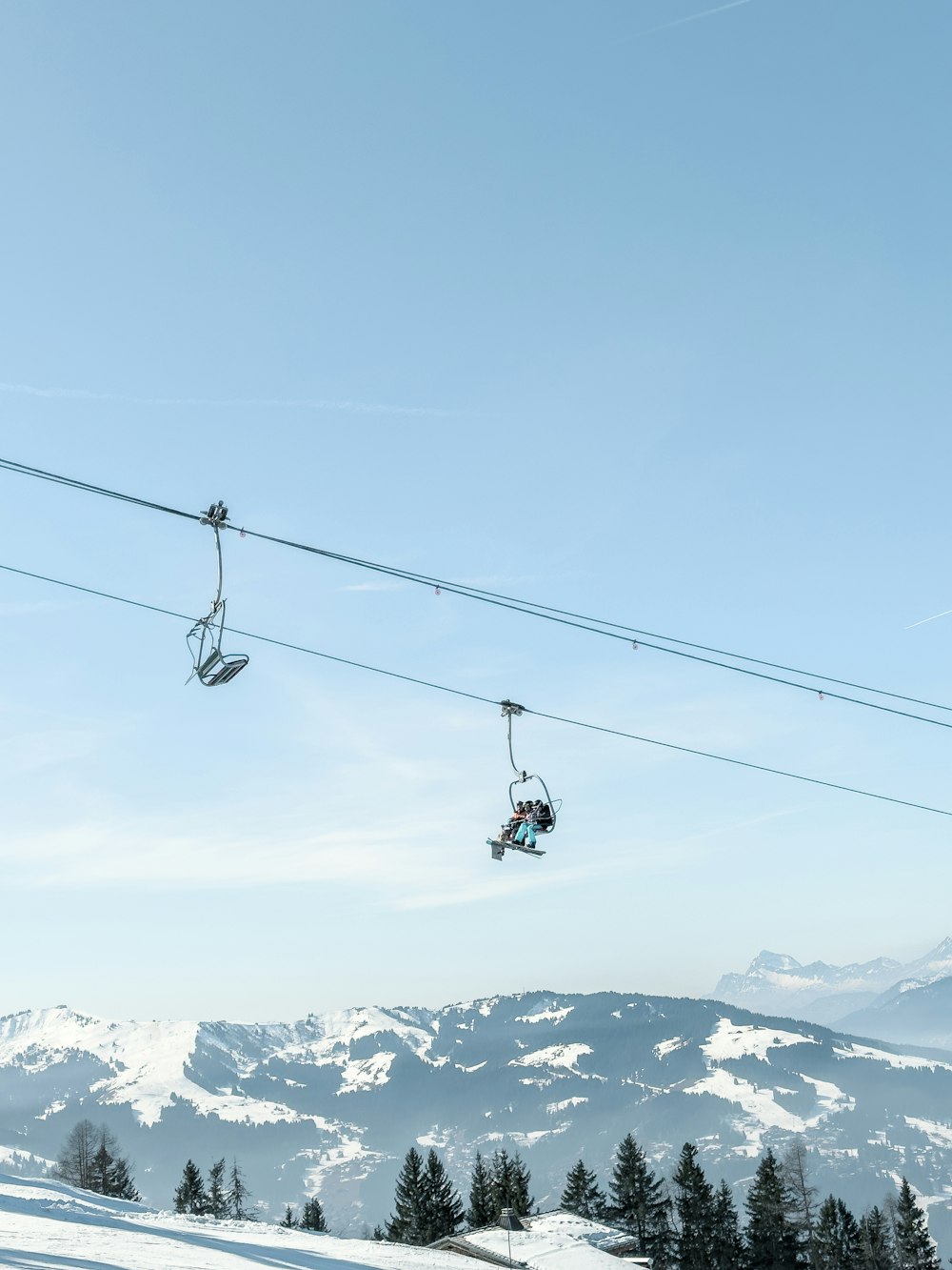 two people riding skis on a ski lift
