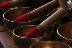 a close up of many metal bowls with wooden handles