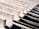 Several parallel concrete beams extend diagonally across the frame, casting deep shadows between them. The beams have a rough texture, and the lighting highlights their angular shapes, creating a pattern of light and dark areas.