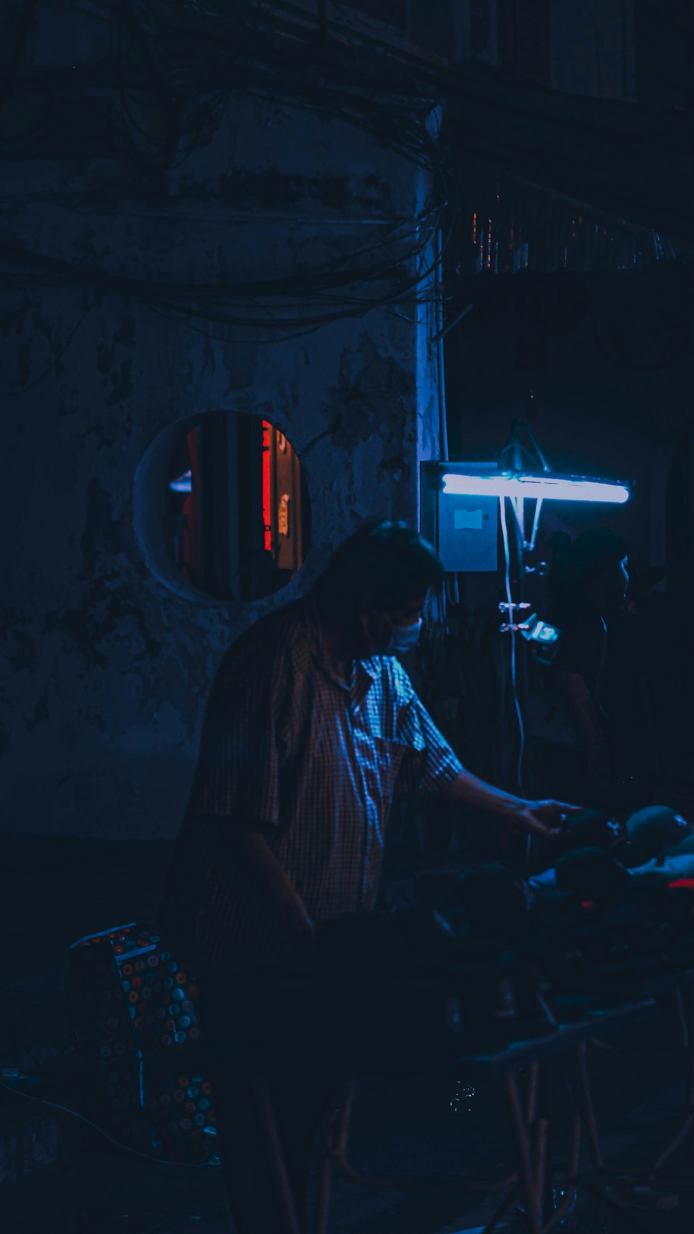 a man in a dark room working on a laptop