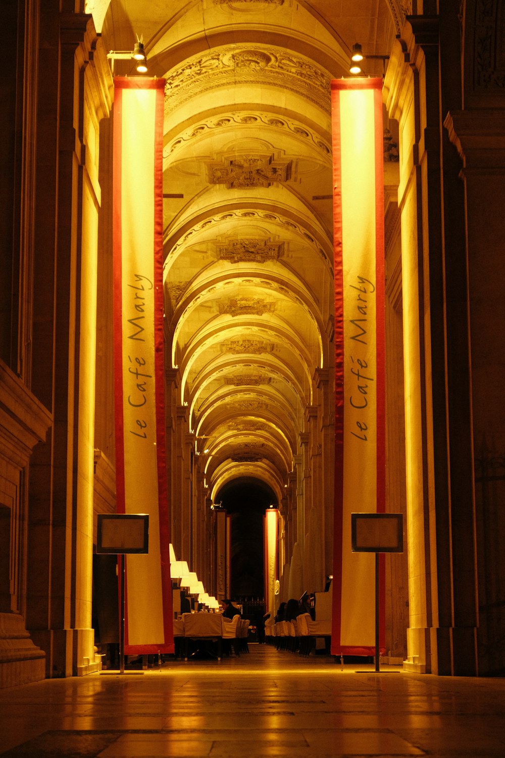 a very long hallway with columns and lights