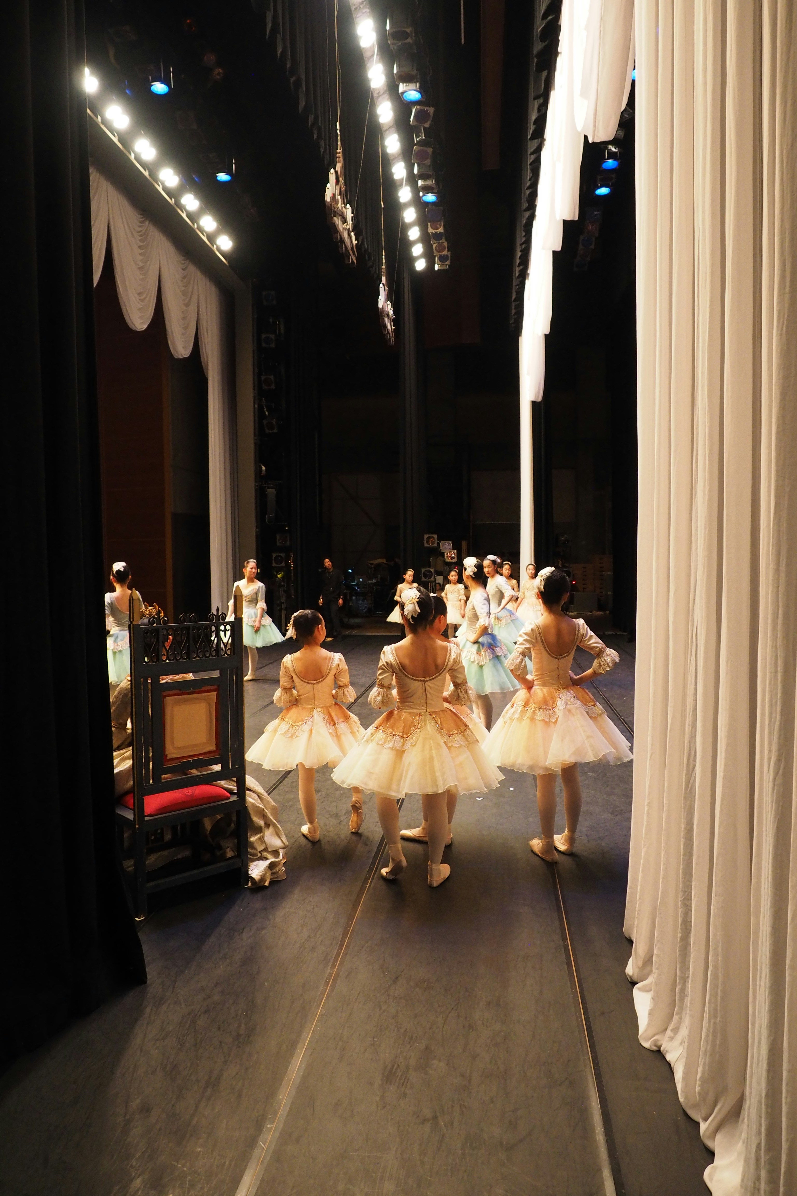 A group of young ballerinas standing on stage