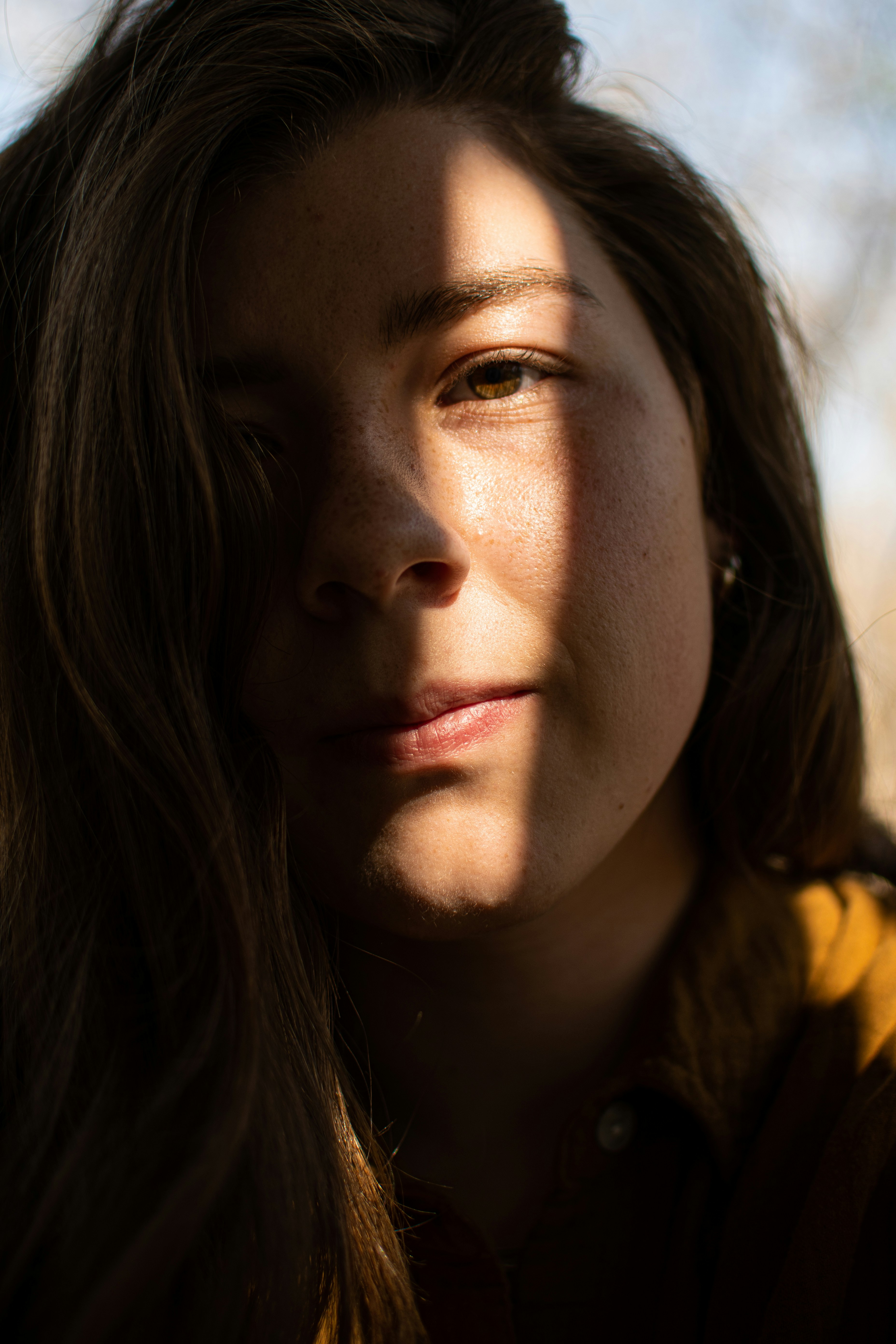 a woman with long hair and a yellow jacket