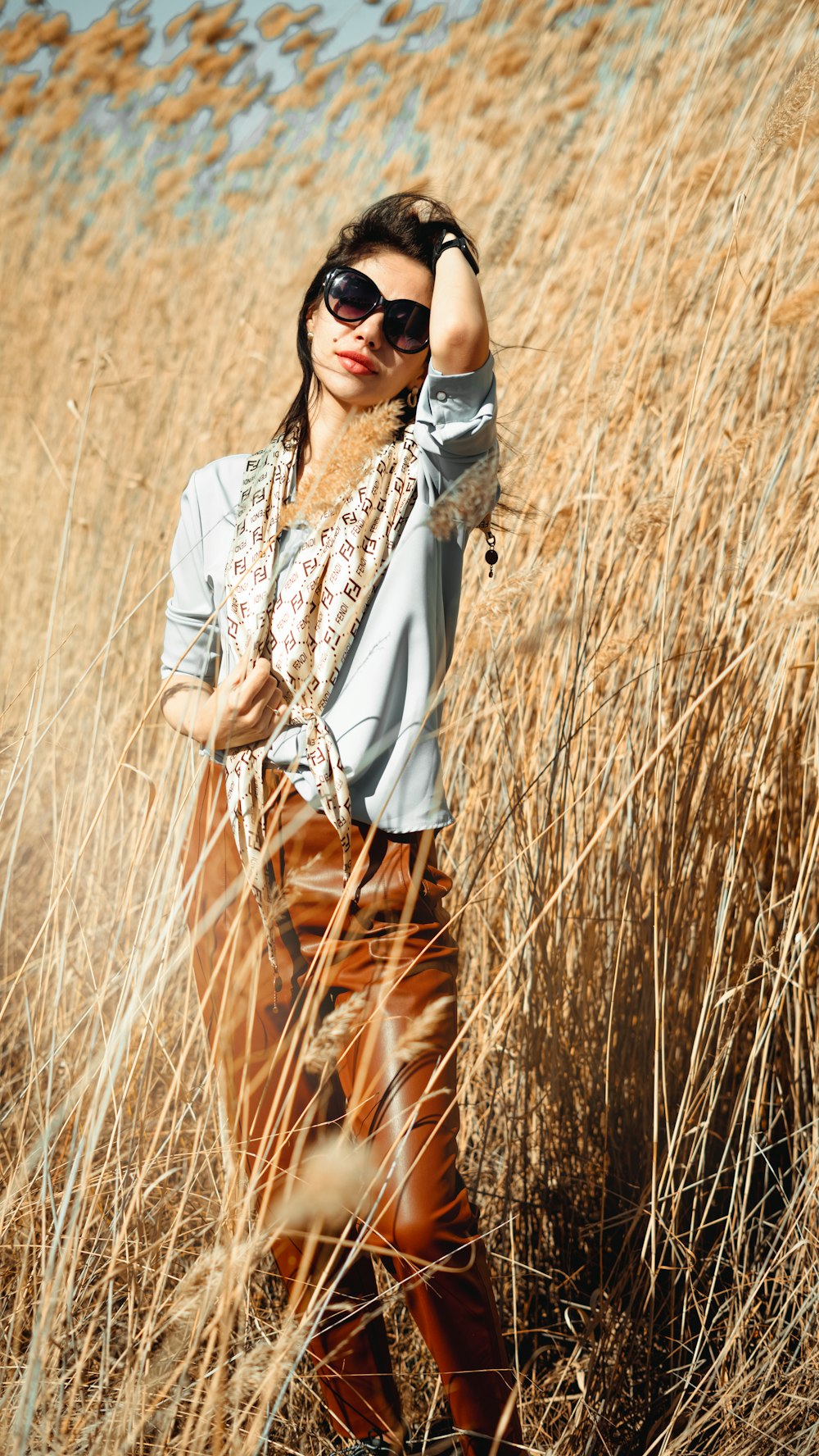 a woman standing in a field of tall grass