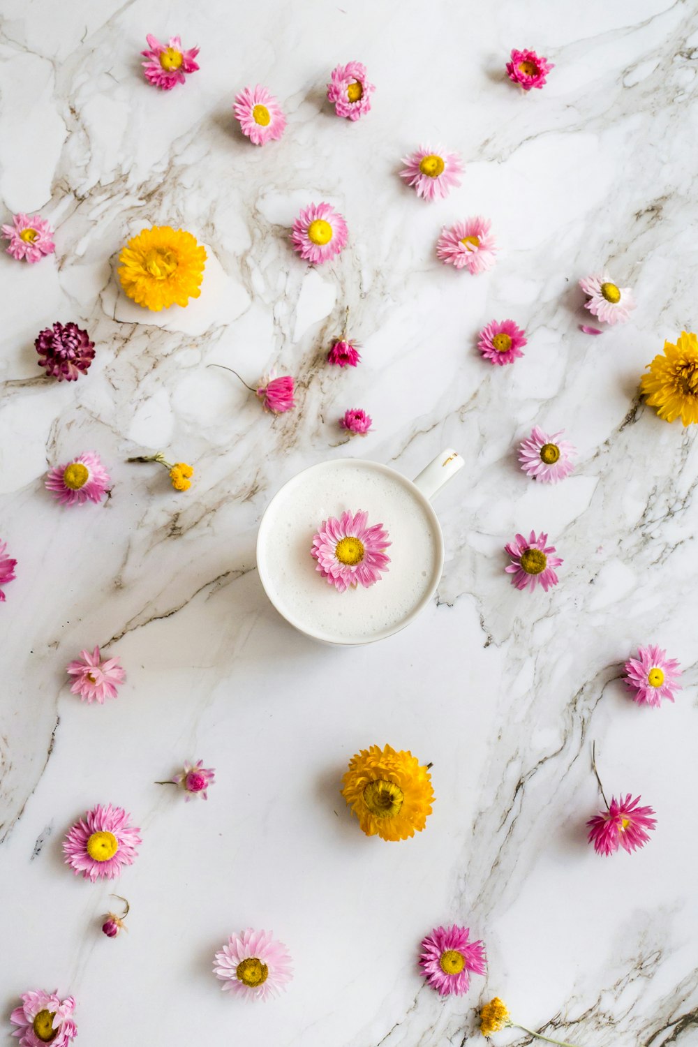 a bowl of flowers on a marble surface