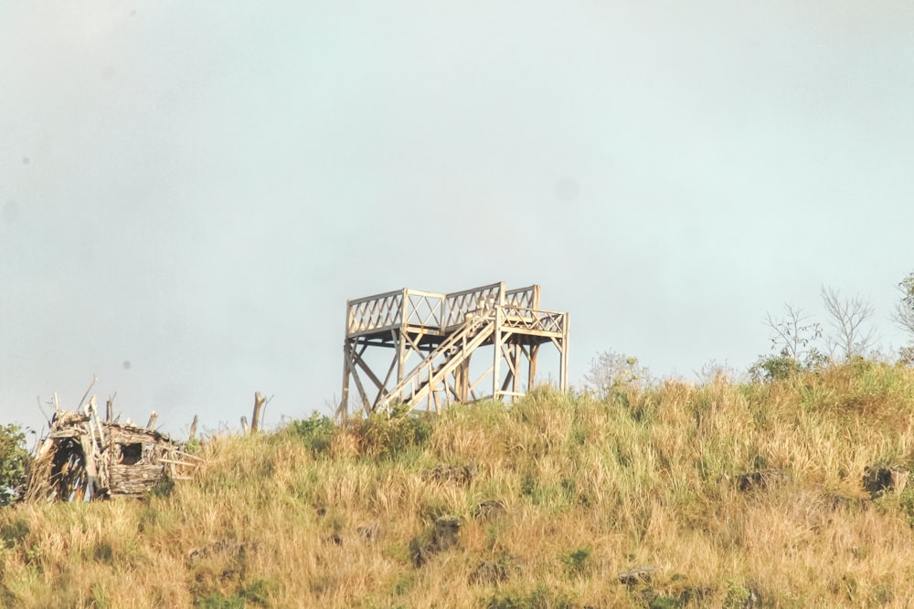 a wooden structure sitting on top of a grass covered hill