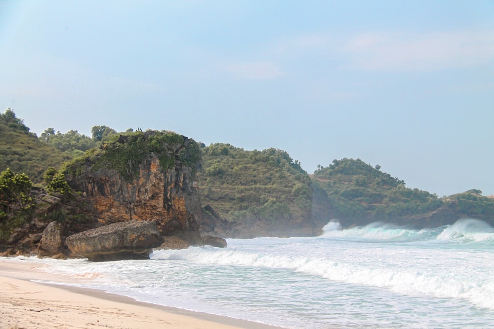 a sandy beach with waves crashing on the shore