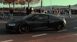 A smiling driving instructor guiding a student in a sleek modern car on a sunny Bern street.