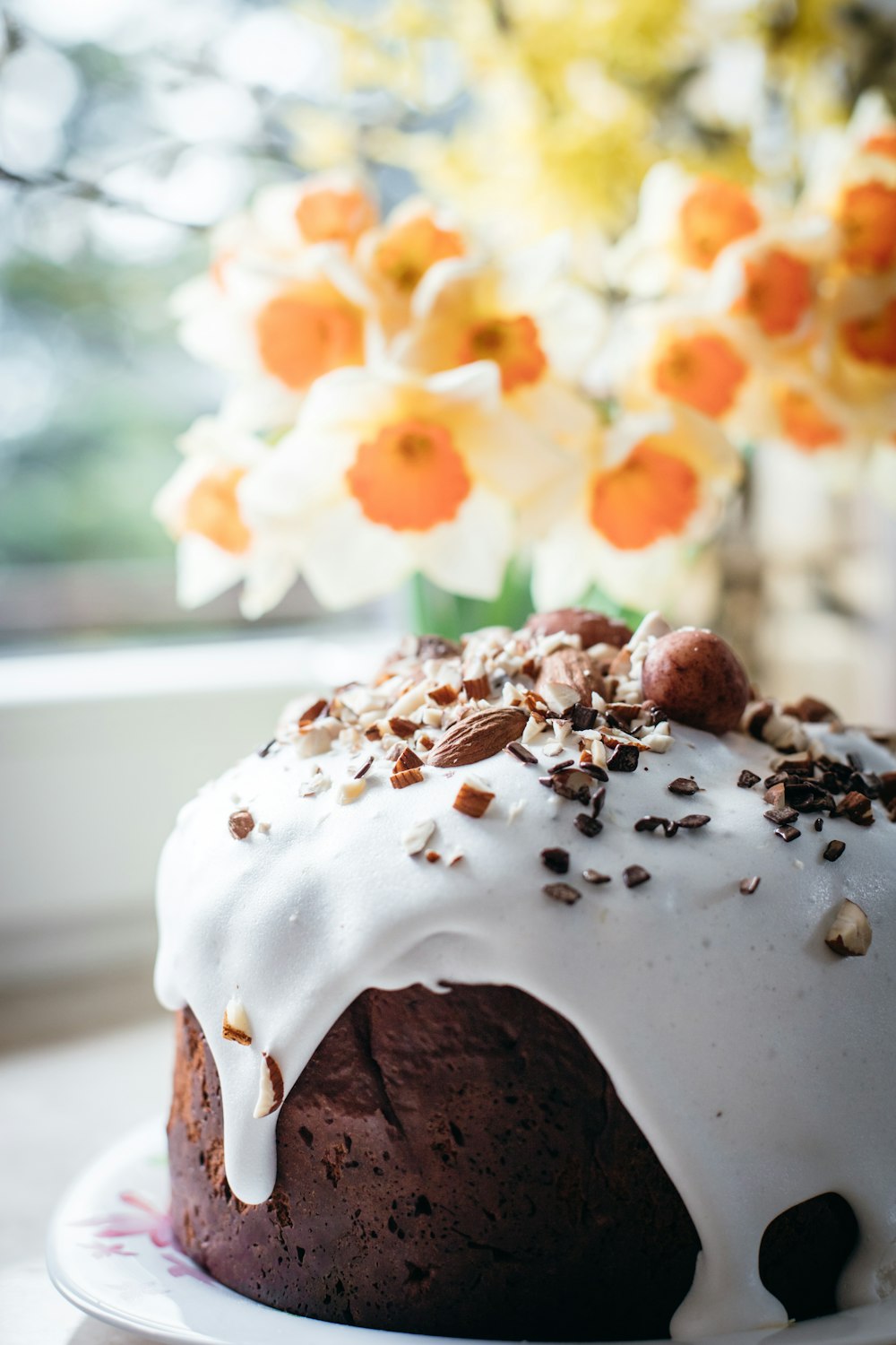 a bundt cake with frosting and nuts on a plate