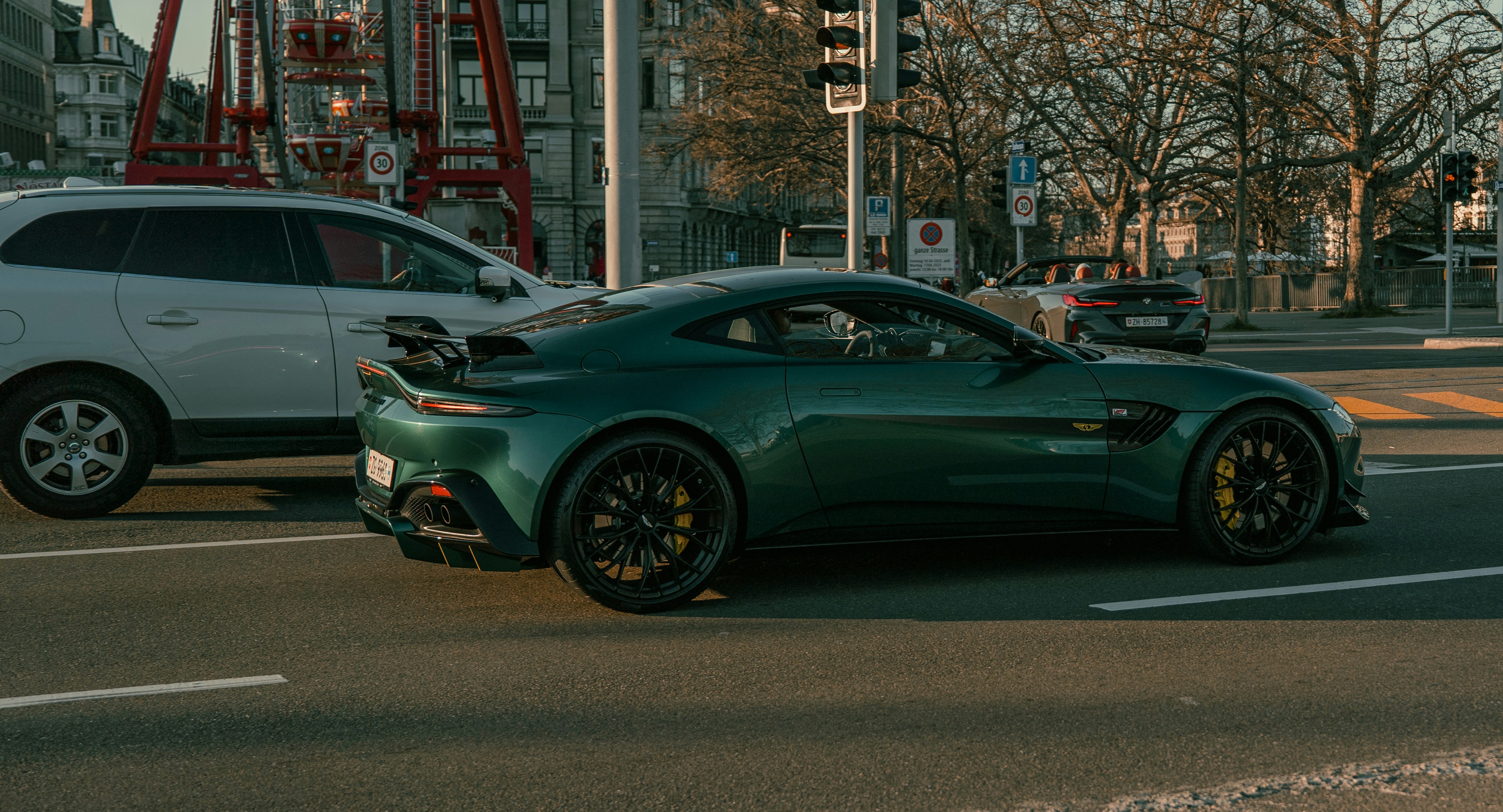a green sports car driving down a city street photo – Free Schweiz ...