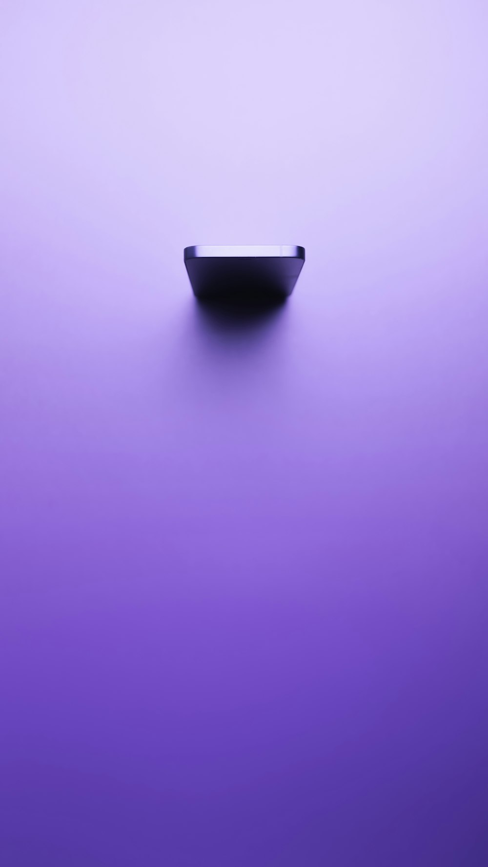 a black bowl sitting on top of a purple table