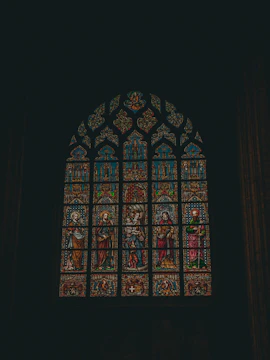 A detailed photograph showing artisans restoring the intricate stained glass windows of Sint-Catharinakerk.