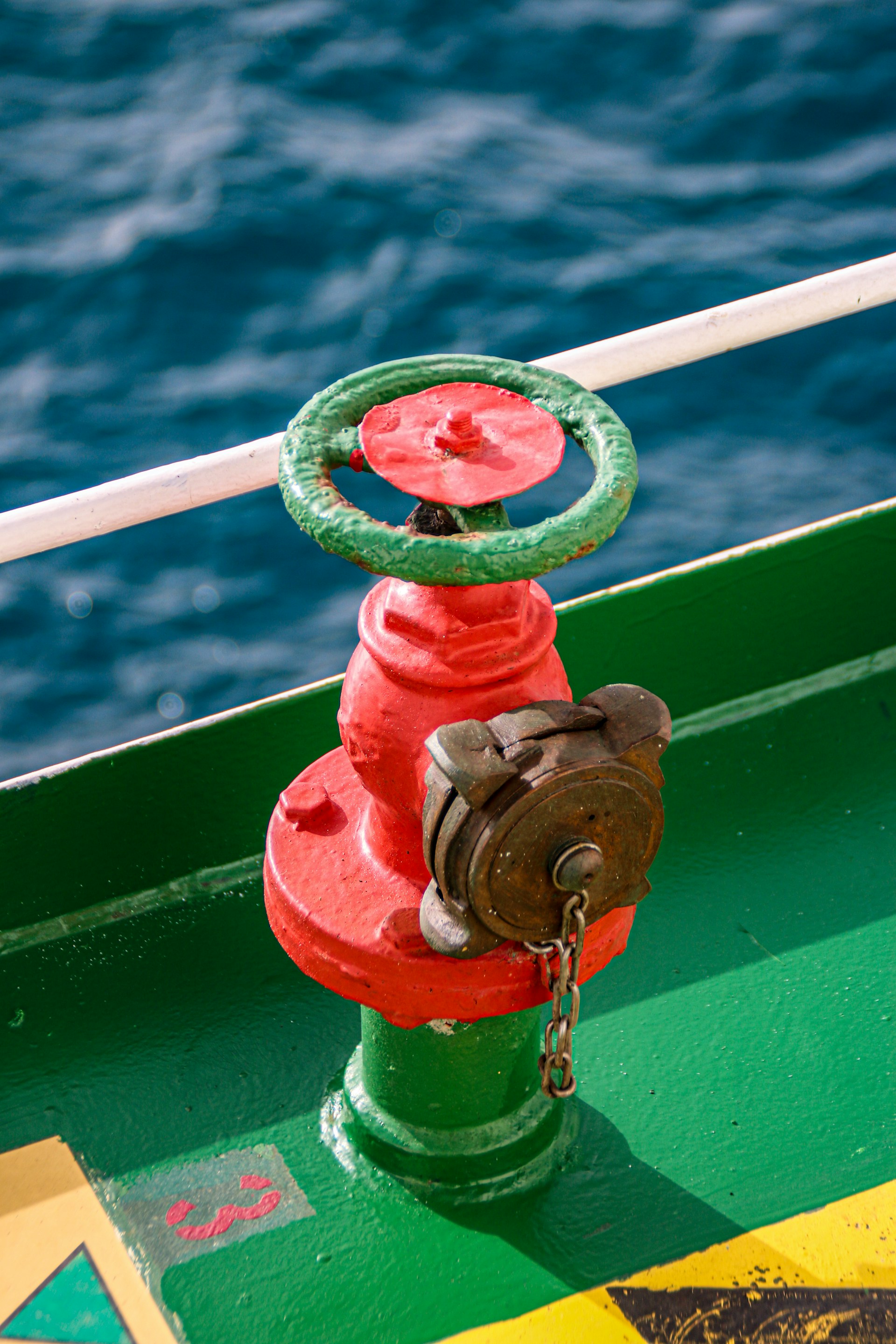 a red and green fire hydrant sitting on top of a green boat