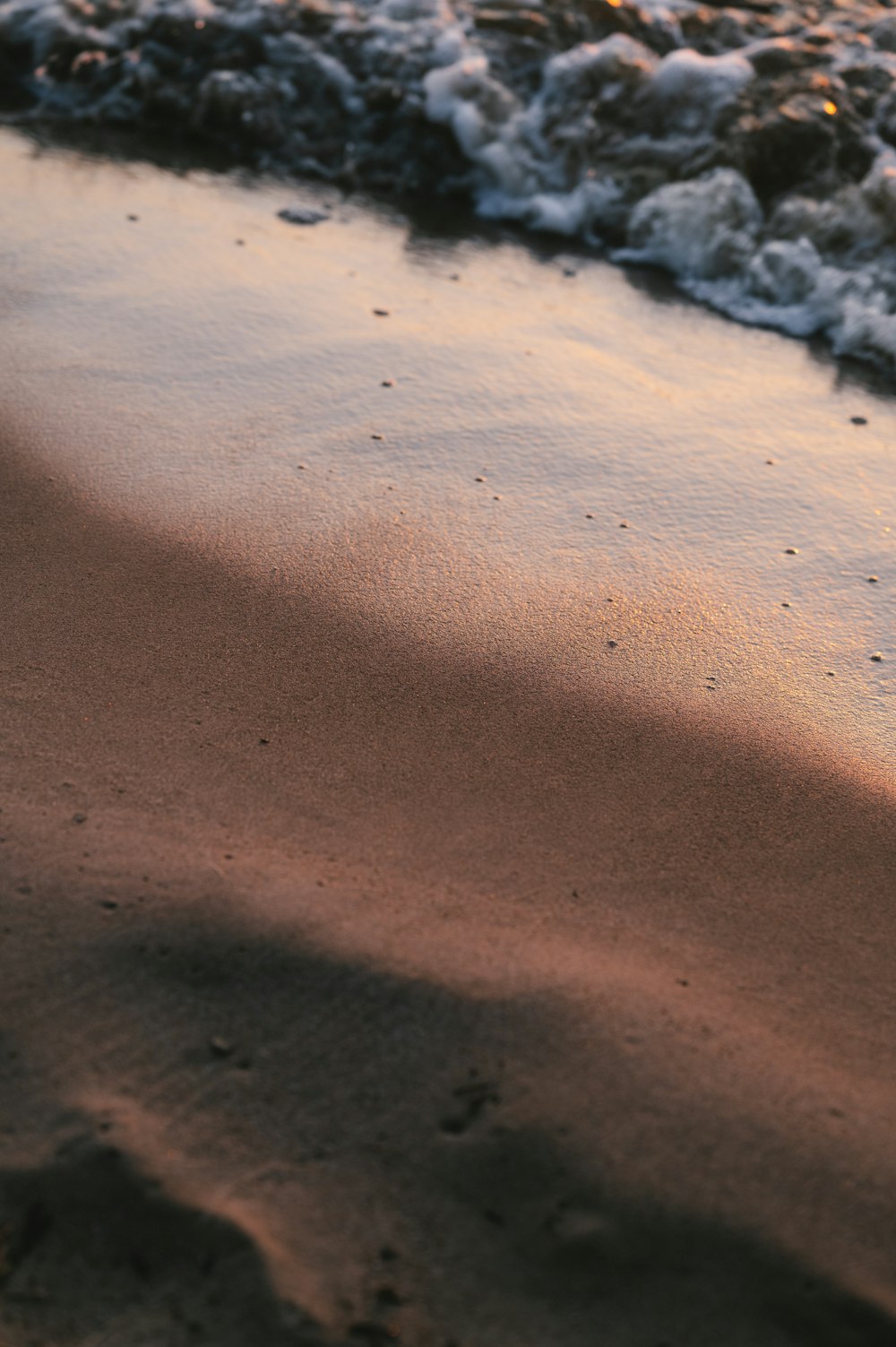 a close up of sand and water on a beach