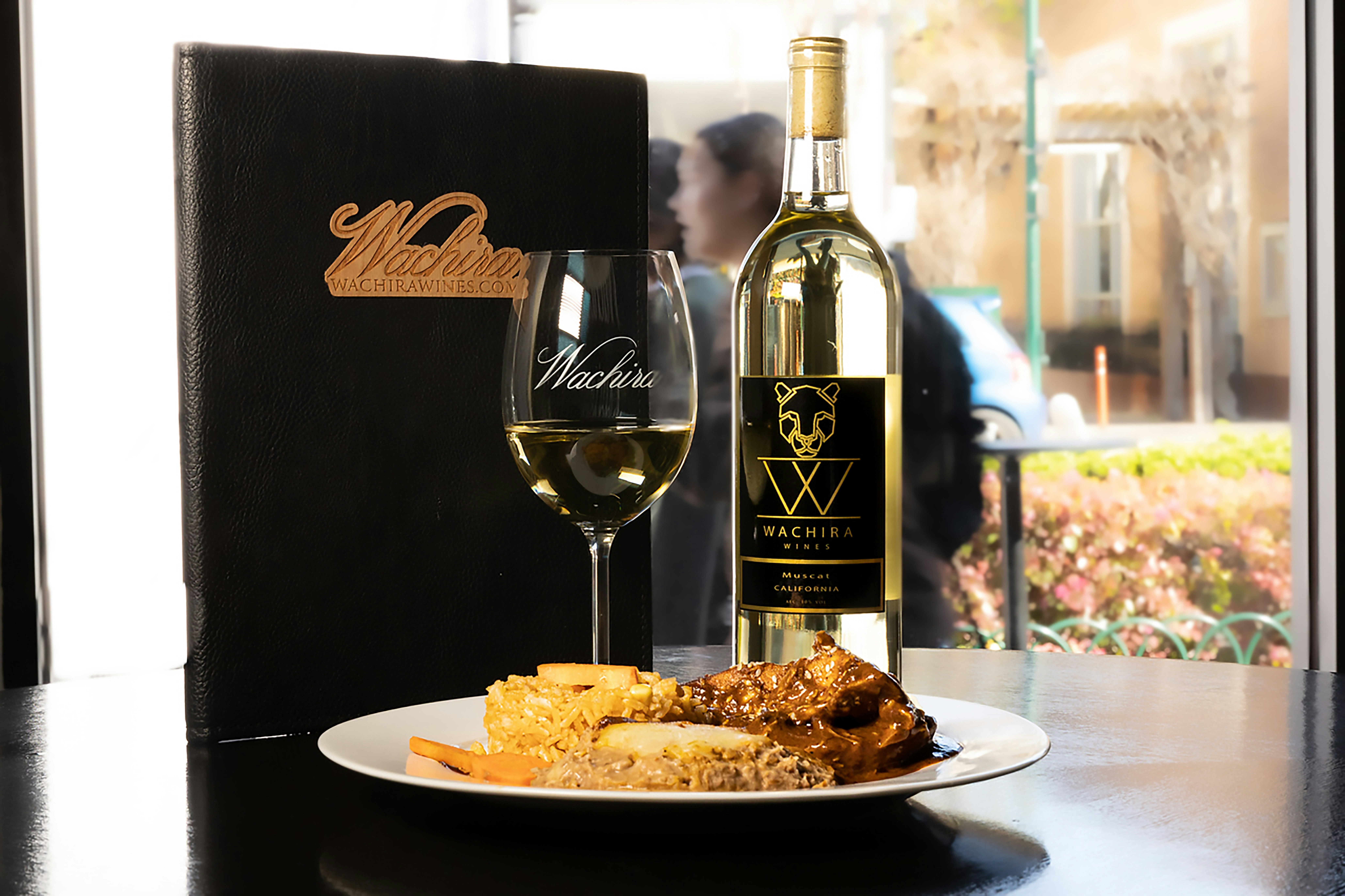 a plate of food and a glass of wine on a table
