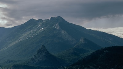 A mountain range with clouds rolling above, symbolizing the untamed beauty of Himalayan ecosystems.