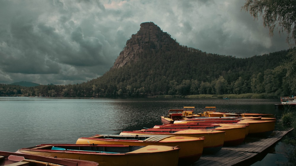 a row of boats sitting on top of a lake