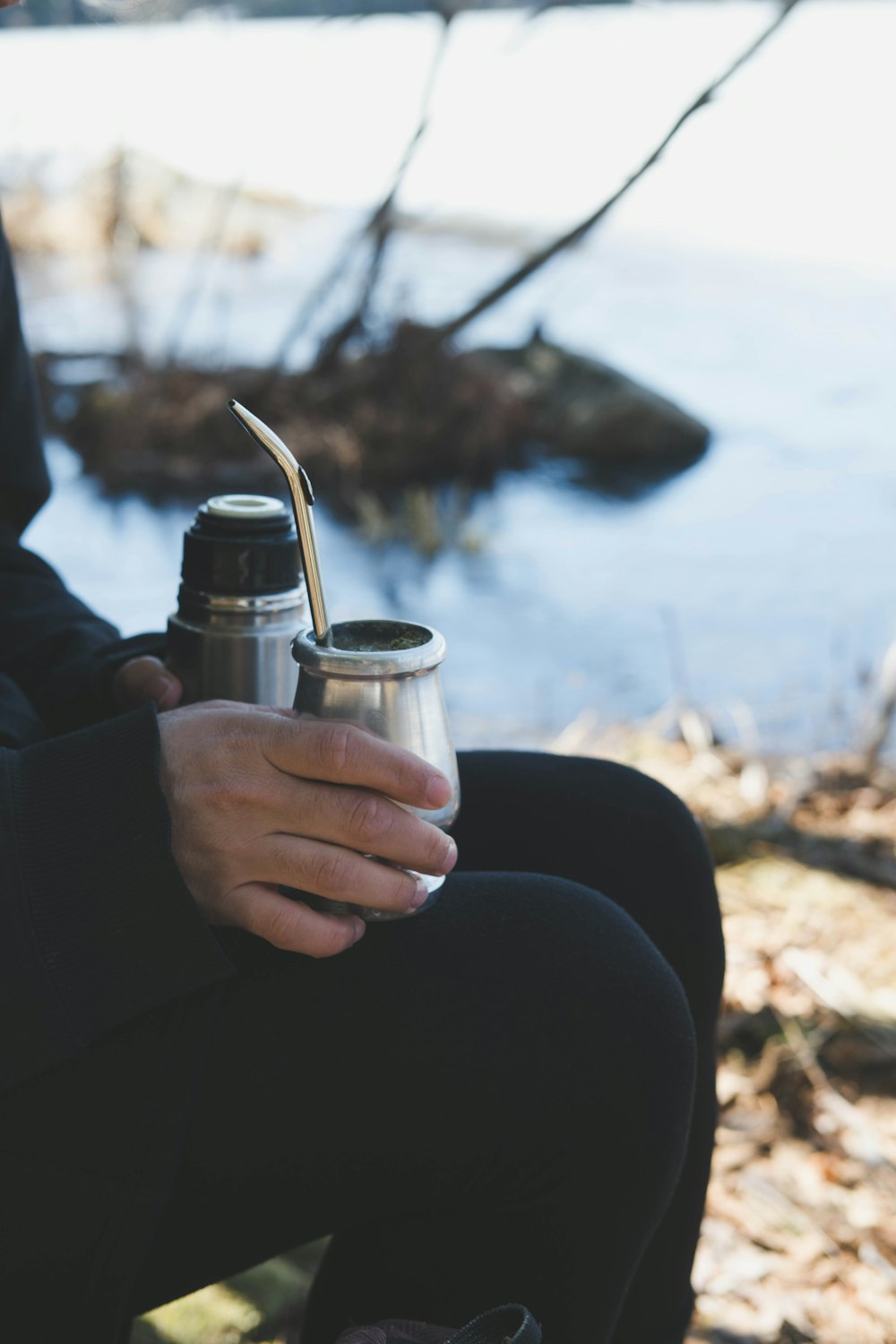 a person sitting on a bench holding a cup