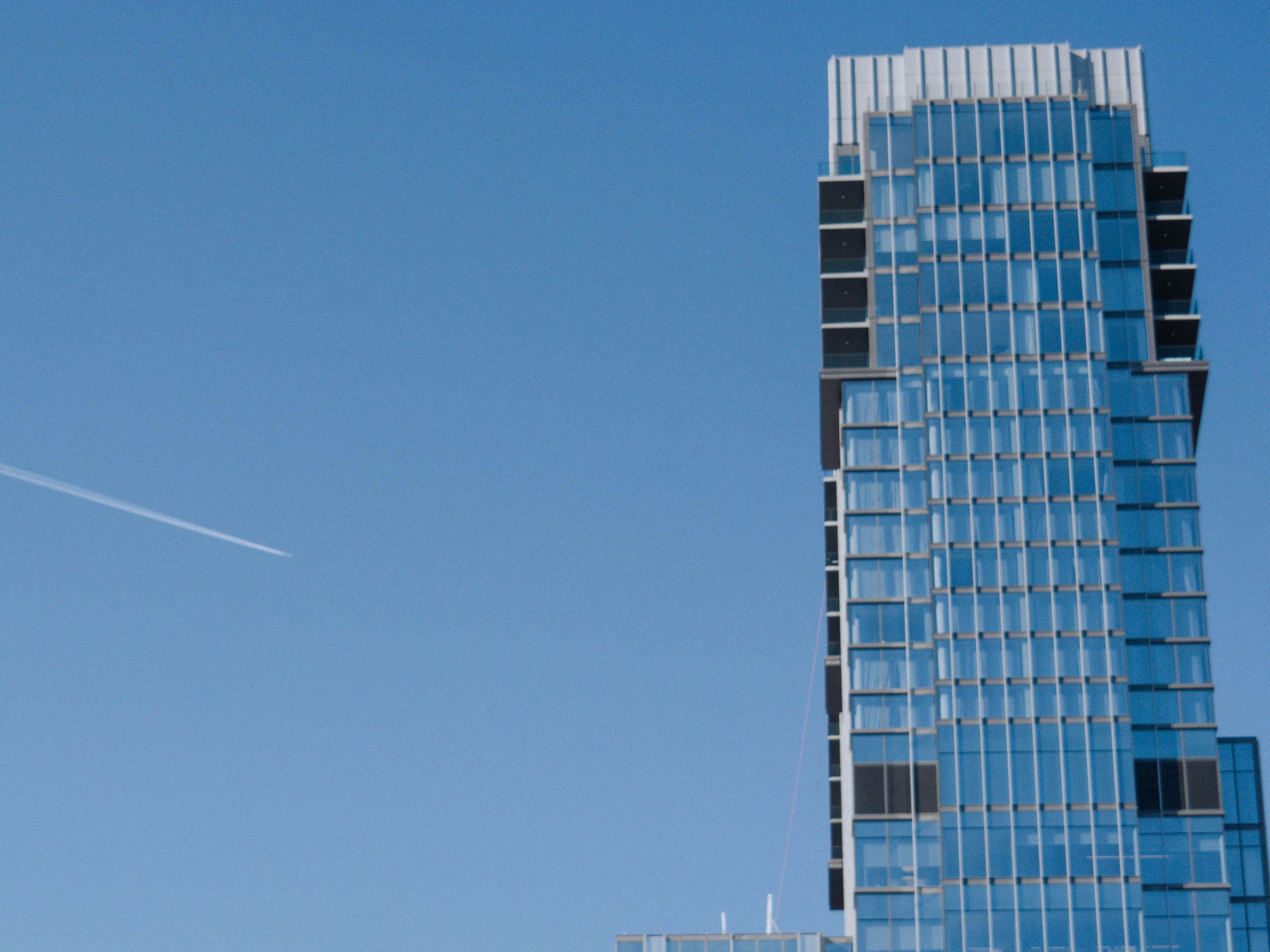 Un avión volando en el cielo cerca de un edificio alto