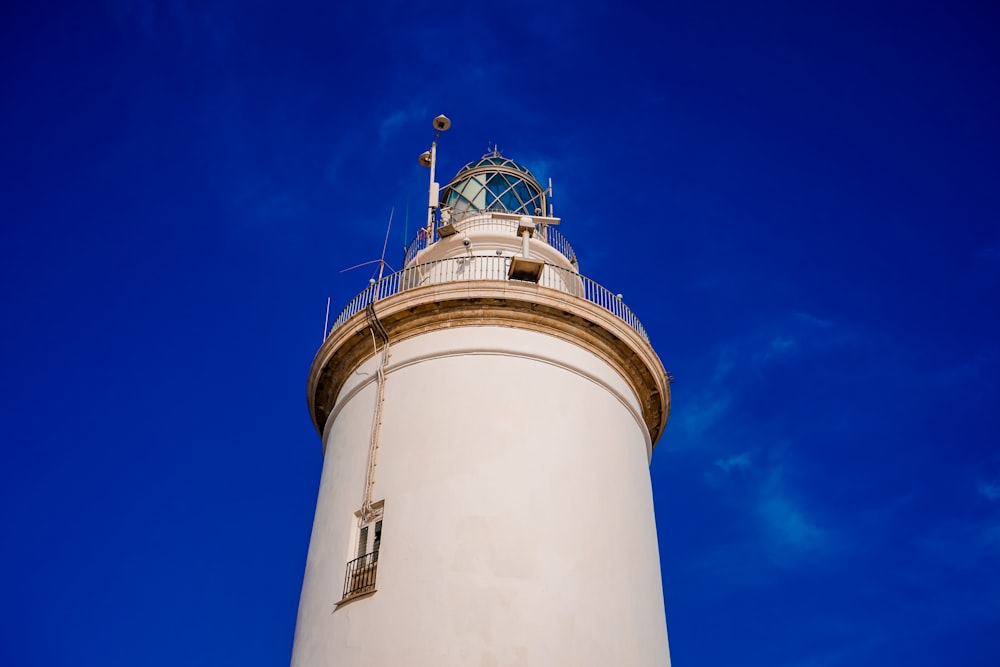 a tall white lighthouse with a clock on top