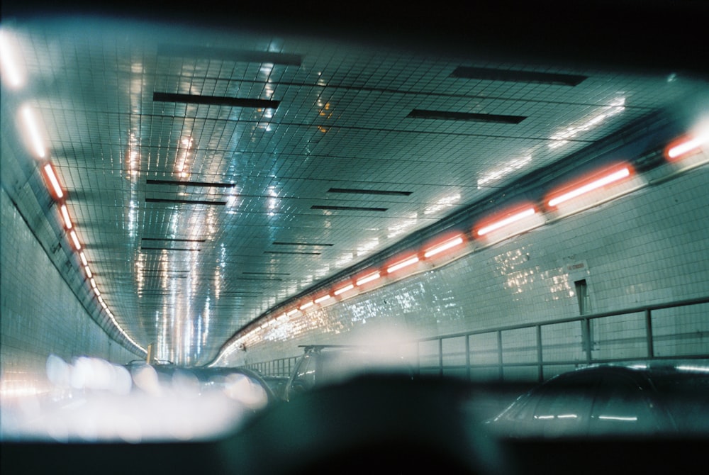 a car driving down a tunnel with lights on