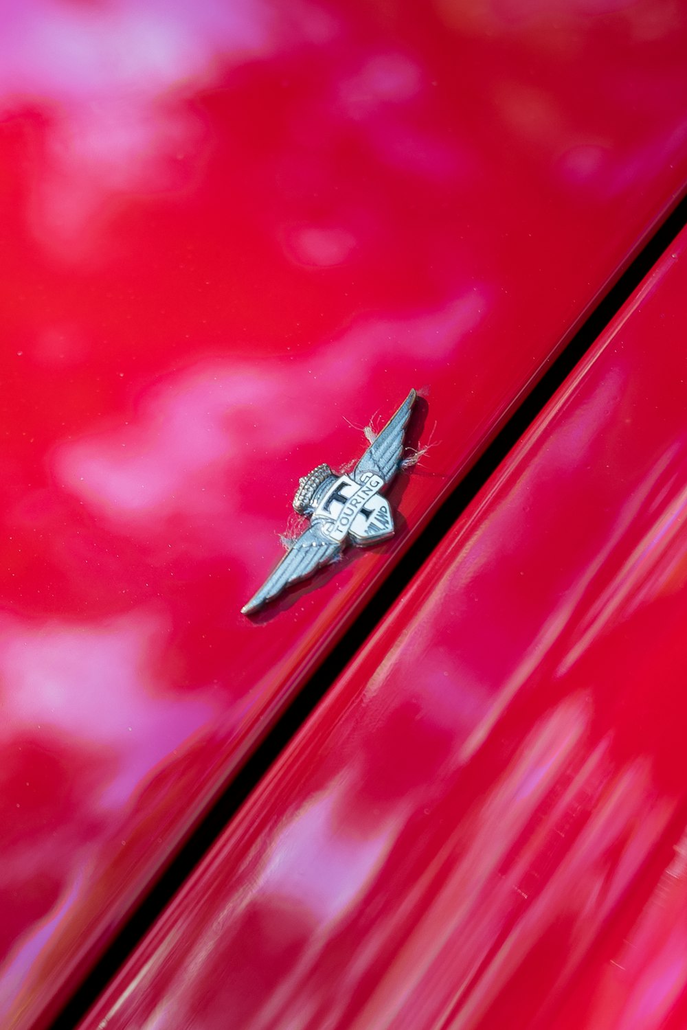 a close up of the hood ornament on a red car