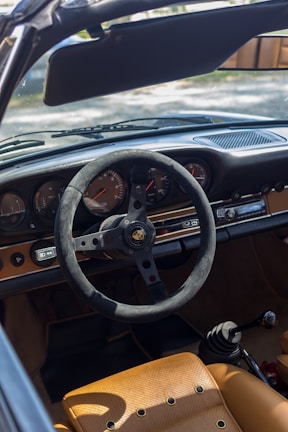 Close-up detail of the Porsche 911’s iconic dashboard with the sun casting reflections.