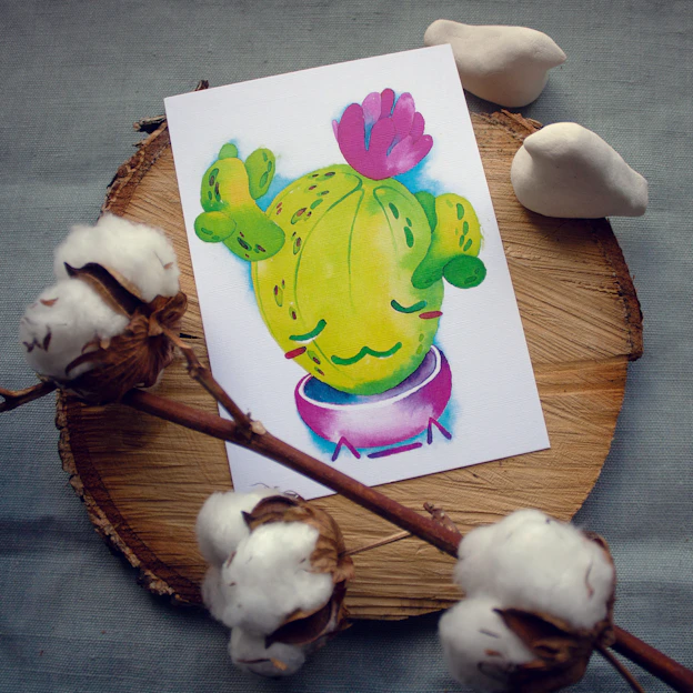 A bright ceramic planter shaped like a smiling cartoon cactus holding a tiny green plant.